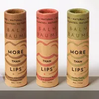 View: Three natural kraft lip balm tubes printed in one colour, standing in a row on a grey surface