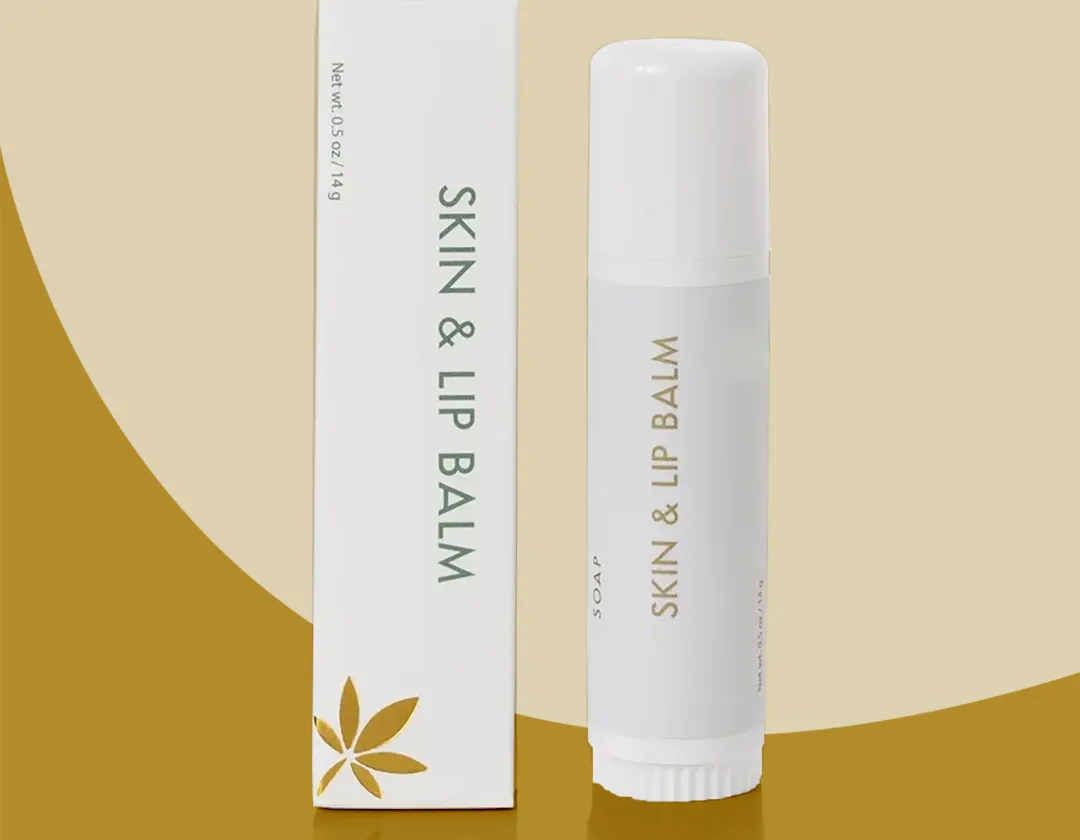 Slim white lip balm carton standing beside a matching white twist-up lip balm tube