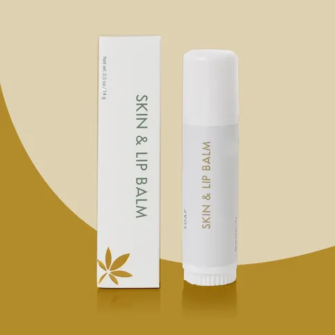 Slim white custom lip balm box standing next to a matching white twist-up lip balm tube