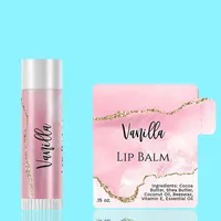 View: Pink watercolour lip balm label next to a matching wrapped lip balm tube on a bright background