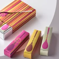 View: Striped lip care gift box open beside three matching slim cartons in pink, yellow and cream