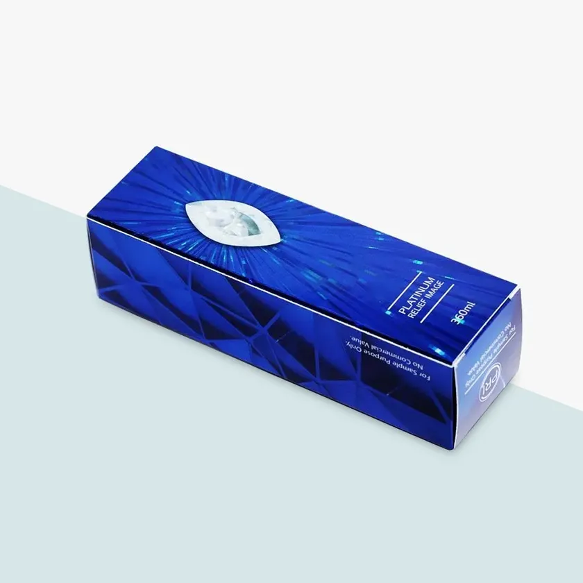Deep blue lipstick box with a faceted pattern and a silver foil oval detail on the front panel
