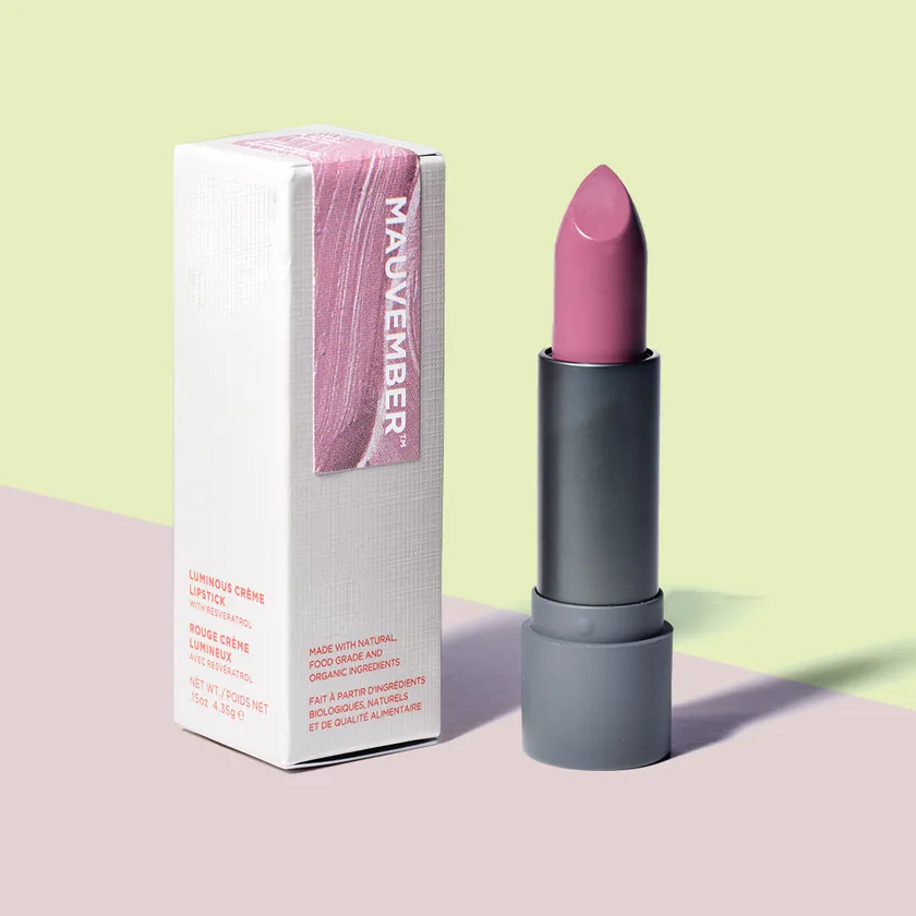White lipstick box with a printed sleeve standing beside an uncapped pink lipstick