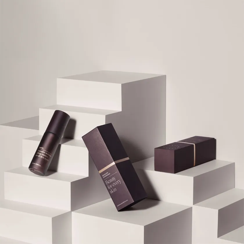 Dark plum lipstick cartons arranged on white display blocks with matching lipstick cases