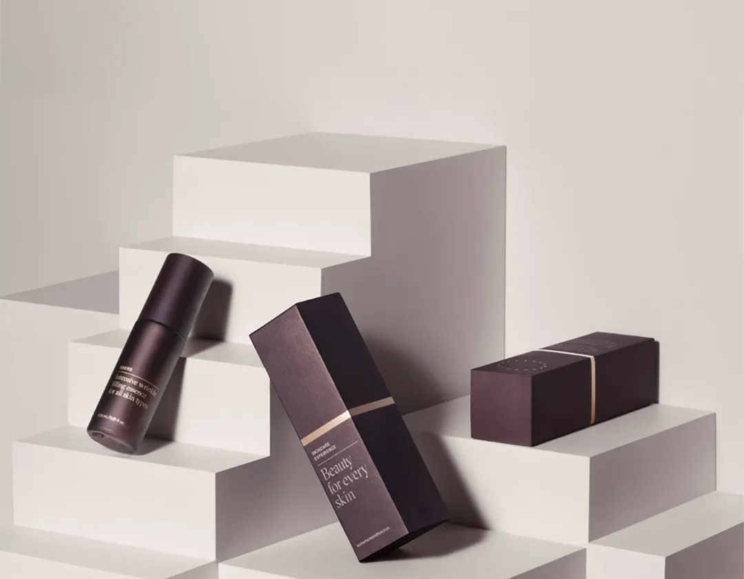 Dark plum lipstick cartons arranged on white display blocks with matching lipstick cases