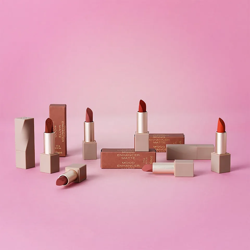 Printed nude and terracotta lipstick boxes arranged with matching lipstick cases